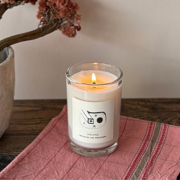 dreams candle on pink fabric
